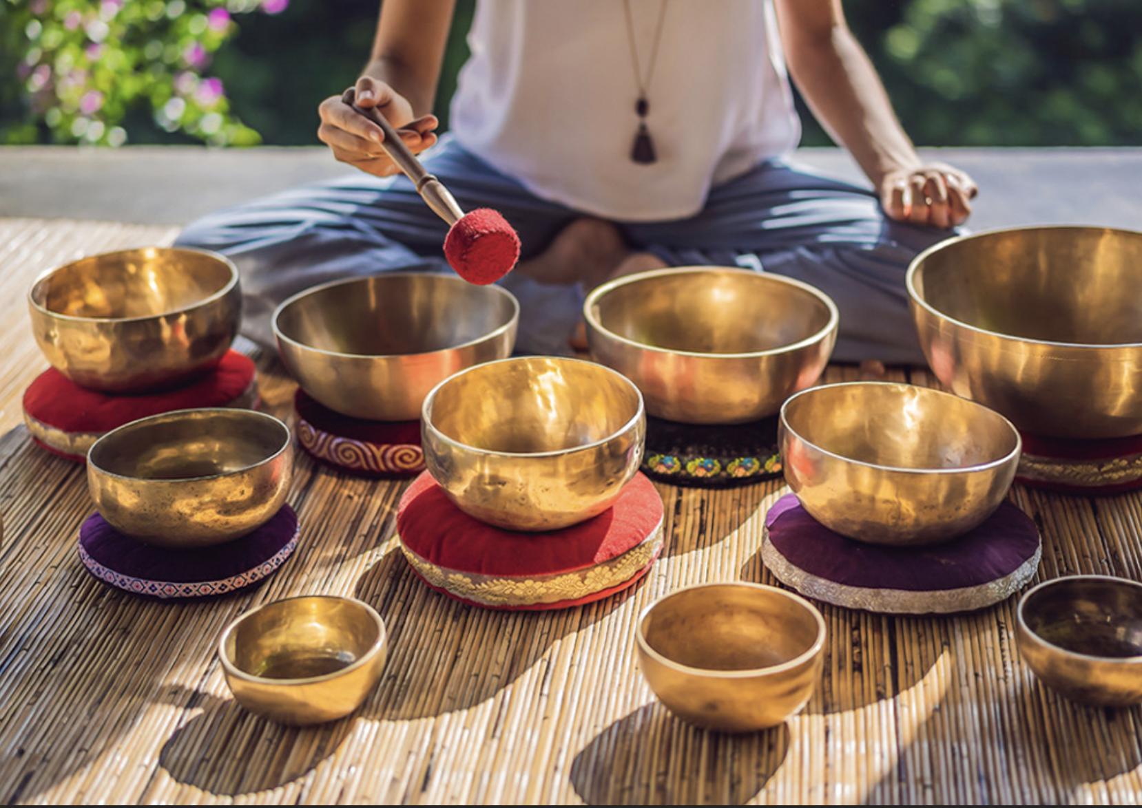 Singing bowls arranged on a bamboo mat for a sound bath wellness class