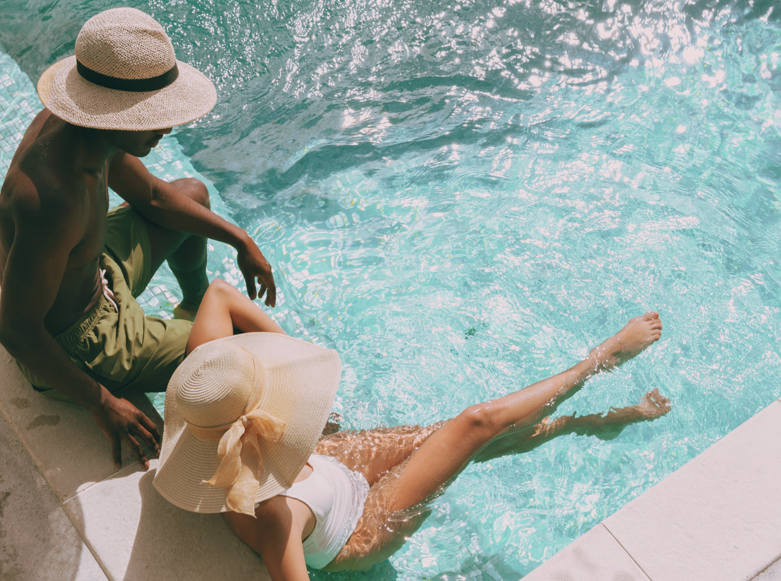 Couple in sun hats relaxing poolside at a Desert Hot Springs spa resort
